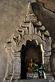 Bagan Myanmar. Htilominlo temple. Niches of the vaulted corridor of the ground floor with stone Buddha images. 